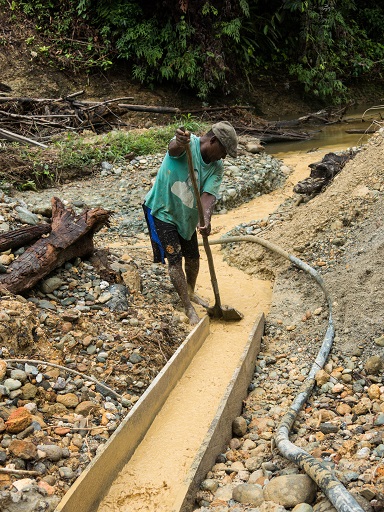 Minero artesanal trabajando en un canalón junto al río